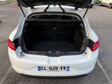 the back of a white car with its trunk open in a parking lot