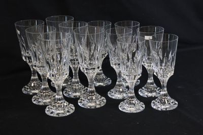 six crystal wine glasses are lined up on a black surface