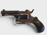 a close up of a small revolver on a white surface