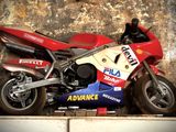 une moto rouge garée sur le bord de la route