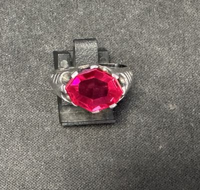 Gros plan sur une bague contenant une pierre rouge