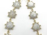 a close up of a pair of earrings on a white surface