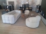 un salon avec un canapé, un fauteuil, une table basse et une télévision
