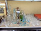 bottles and glasses on a table with a mirror in the background
