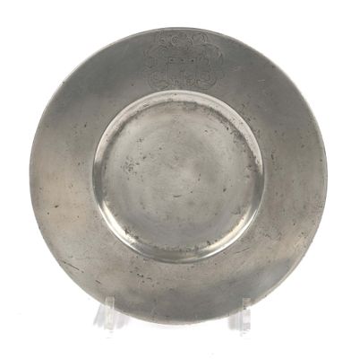 a silver plate on a stand on a white surface