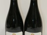 deux bouteilles de vin posées sur une table l'une à côté de l'autre