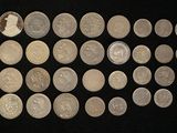 some silver coins are arranged in a row on a black surface