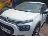 a small white car that is parked on the side of the road