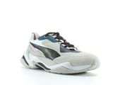 Les baskets Puma sont blanches et noires, avec des touches de violet.