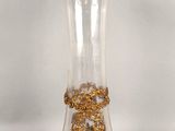 a glass vase with a gold decoration on it