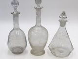 trois carafes en verre transparent avec un bouchon en argent et un bouchon en argent