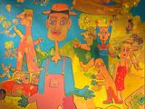 painting on the wall of a children ' s playroom with a man and a dog