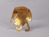 a close up of a gold object on a white surface