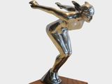 statue of a female figure on a wooden base with a white background