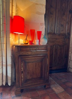 a wooden cabinet with a red lamp on top of it