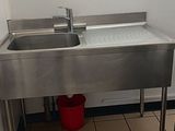 une salle de bains avec un lavabo et des seaux posés par terre