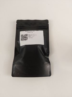un sac noir rempli de nourriture posé sur une table blanche