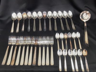 many spoons and forks laid out on a table
