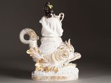 a figurine of a woman and a cat sitting on top of a fish