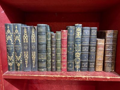 de nombreux livres anciens sur une étagère, dans une boîte rouge