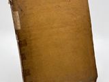 an old book that is sitting on a white surface