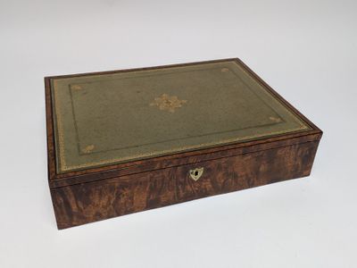 an old wooden box with a green cover on a white surface