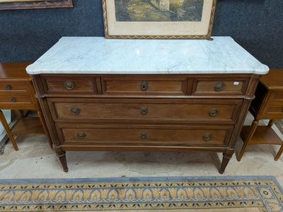 a marble top dresser in a room with a painting on the wall