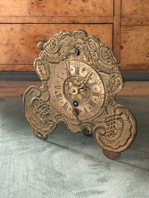 a clock that is sitting on the floor next to a dresser