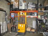 a forklift in a garage with lots of boxes on the shelves