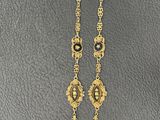 a necklace with a gold chain and a pearl bead