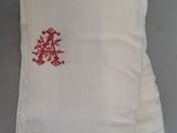 une serviette blanche ornée d'un motif rouge