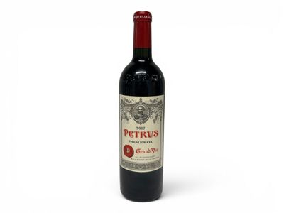 a bottle of red wine sitting on top of a white table