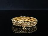 a close up of a gold bracelet on a black surface