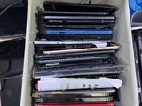 a lot of laptops in a container on a desk