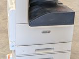 a white printer sitting on top of a cart in a warehouse