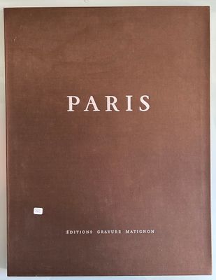 un livre brun posé sur une table à côté d'un mur blanc
