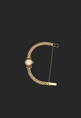 un bracelet en or auquel est suspendue une montre sur le côté