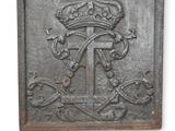 une vieille plaque métallique sur laquelle figurent une couronne et une croix