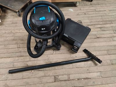 a vacuum that is sitting on the floor next to some tools