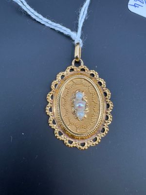 une photo d'un collier en or sur lequel figure le portrait d'une femme