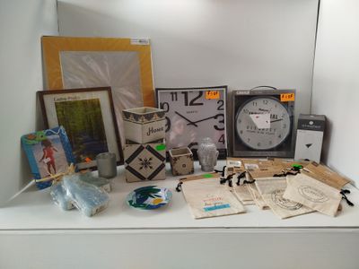 une étagère blanche sur laquelle sont posés une horloge, des photos et d'autres objets