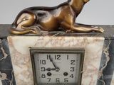 marble clock with a bronze dog sitting on top of it