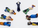 sept figurines représentant des personnes de différentes couleurs sur un fond blanc