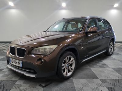 the bmw x1 is parked in the garage on a checkered floor