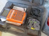 an orange calculator sitting in a case on the floor