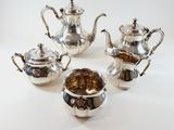 four pieces of silver tea and coffee set on a white background