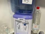un distributeur d'eau posé sur un plan de travail à côté d'un évier