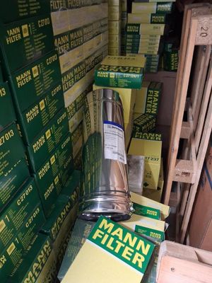 une pile de cartons et un tuyau métallique dans une pièce