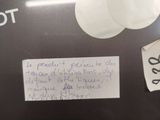 a sign on the side of a toilet that has a sticker attached to it