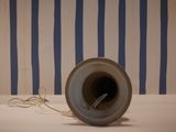a white and blue striped wall with a vase on it